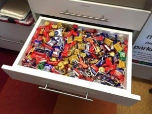 Desk drawer full of candy.