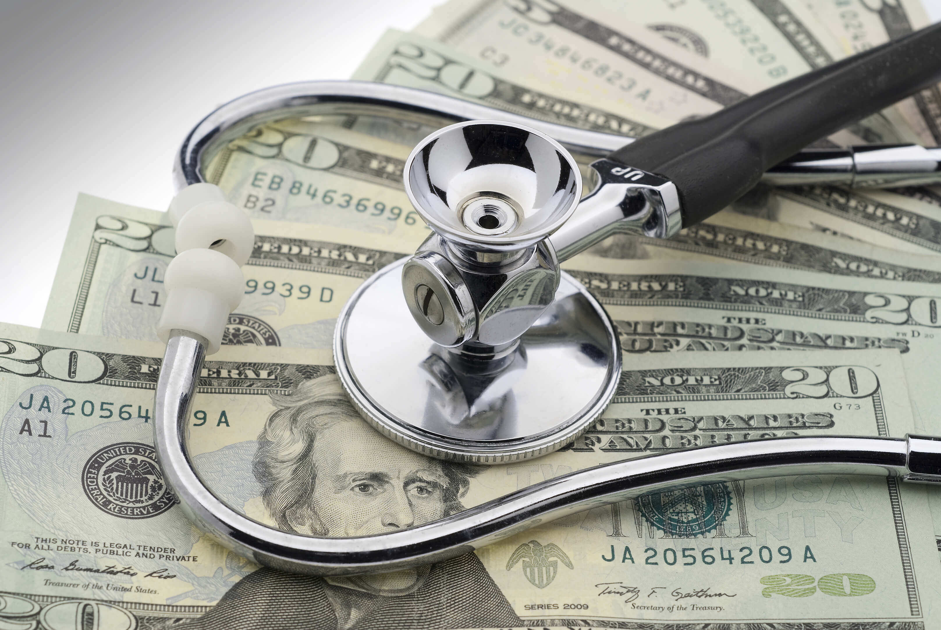 Image of a stethoscope on top of a stack of cash.