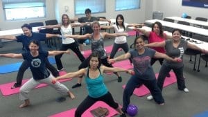 Group of women doing group yoga with light weights