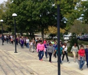 Large group of workers talking an outdoor walk.