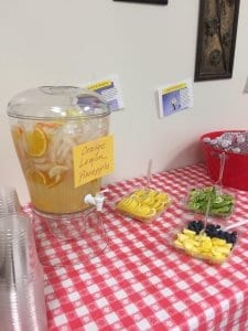 Breakroom table set up with fresh fruit and fruit juice.