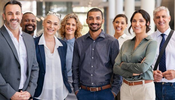 Group of people in business casual clothing smiling.