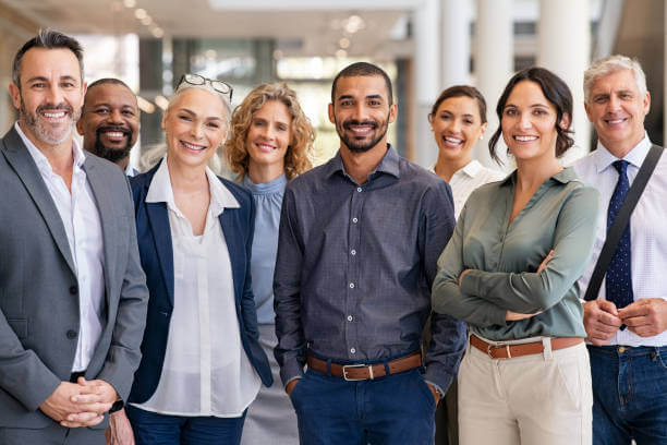 Group of people in business casual clothing smiling.