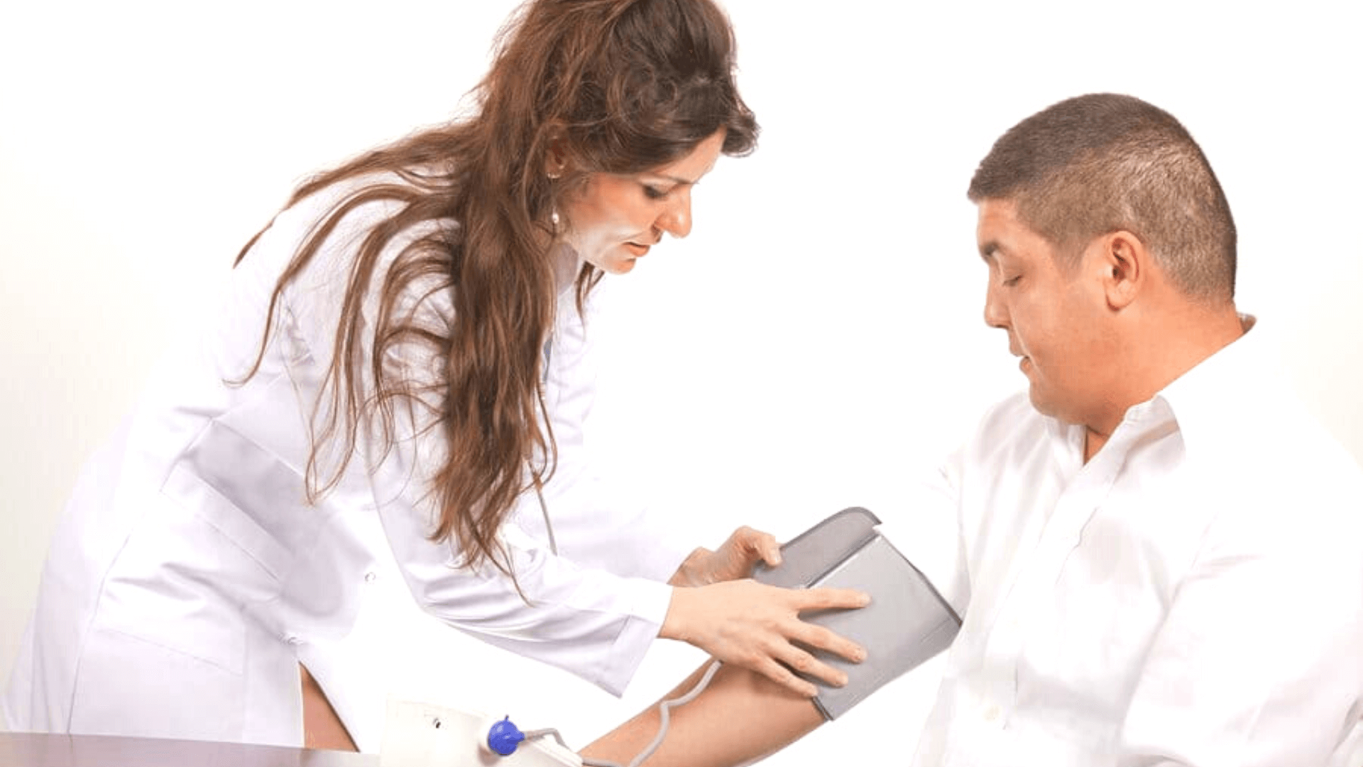 Woman in a white coat applying a blood pressure cuff to a middle aged man.