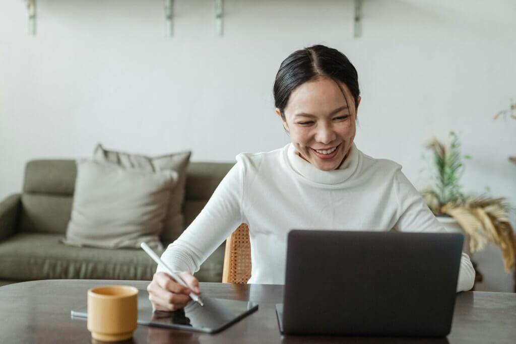 Woman working happily at a home office desk.