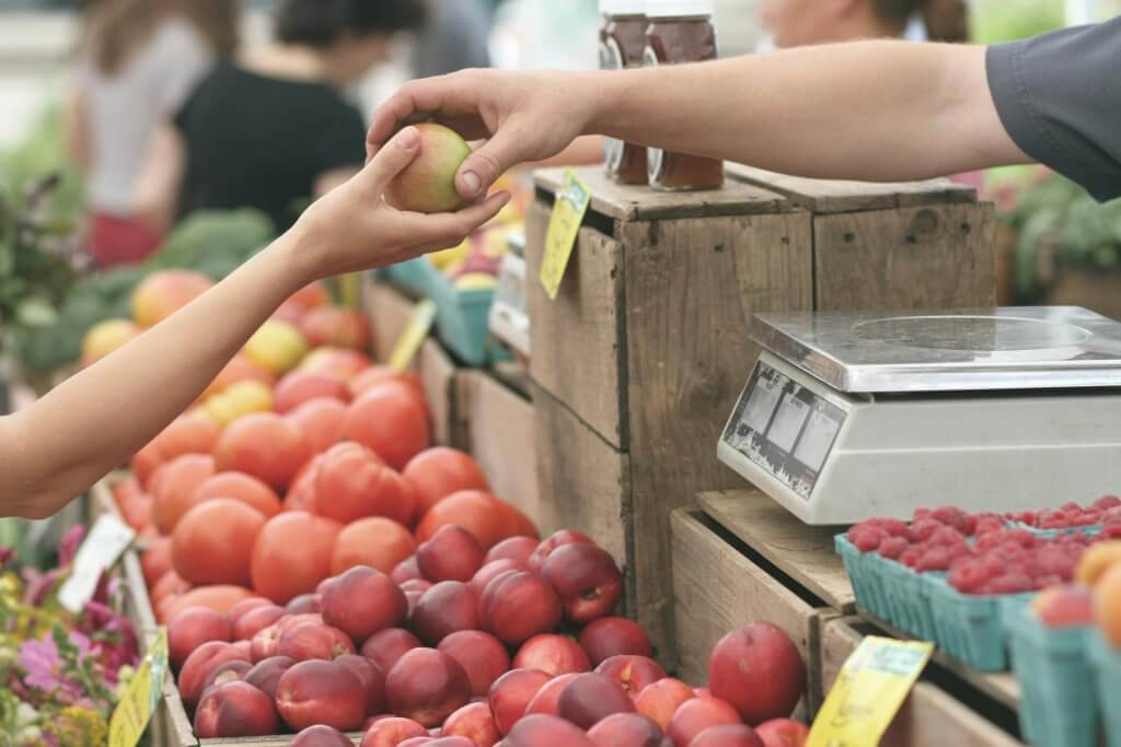 Individual purchasing healthy fruit to promote health.